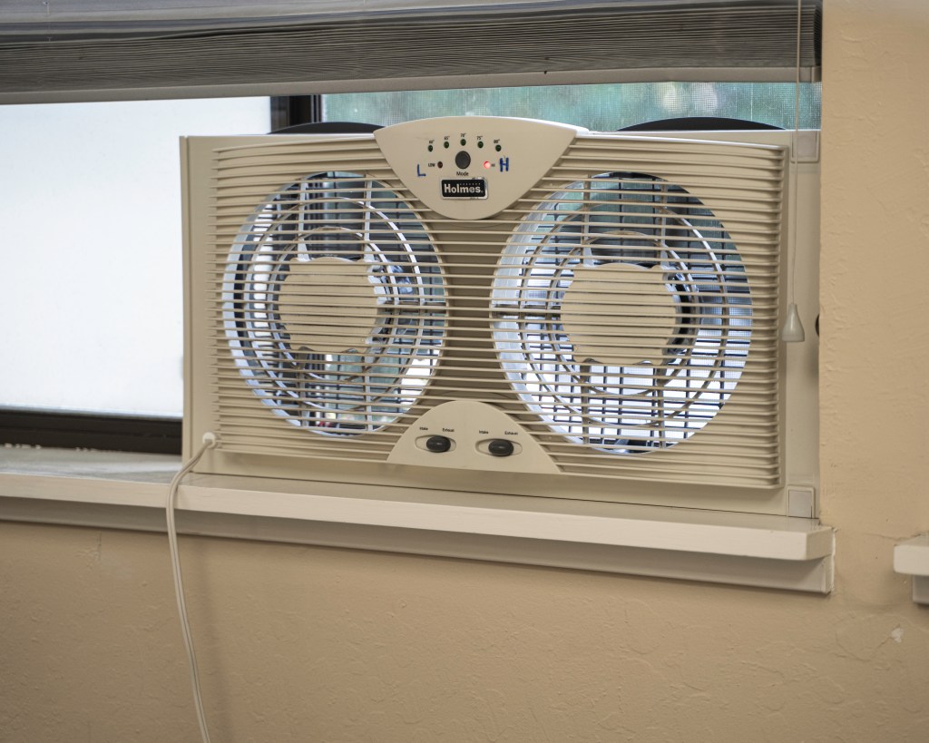 Holmes fan with intake and exhaust so that exam rooms can be ventilated with aerosol outflow prevented into common areas. During patient care, the exhaust works efficiently to vent to the parking lot. Photo by Brian Ringo, 2023.