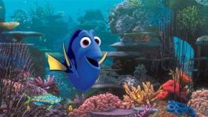 An animated scene from the Pixar film "Finding Dory." Dory, the central character who is a blue tang, in an underwater coral reef.