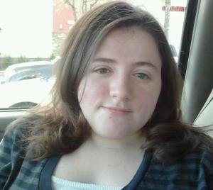 Caucasian female with brown hair wearing a black shirt facing camera.