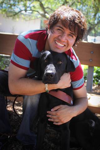 Photo of Belo Cipriani and his guide dog, Oslo, a black lab.