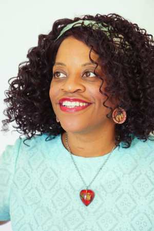 Profile headshot of Black woman with curly hair, staring ahead.