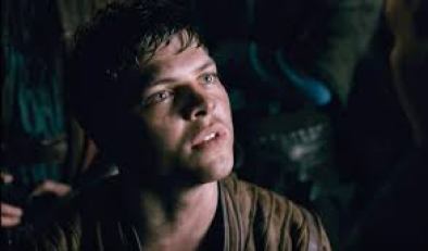 Image description: screenshot from an episode of Vikings, an original series on the History Channel. Ivar the Boneless is a young Viking warrior wearing a brown shirt. His hair looks damp and he has a pensive expression on his face.