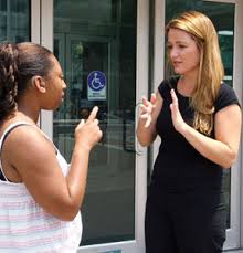 Image of two women using sign language with each other.