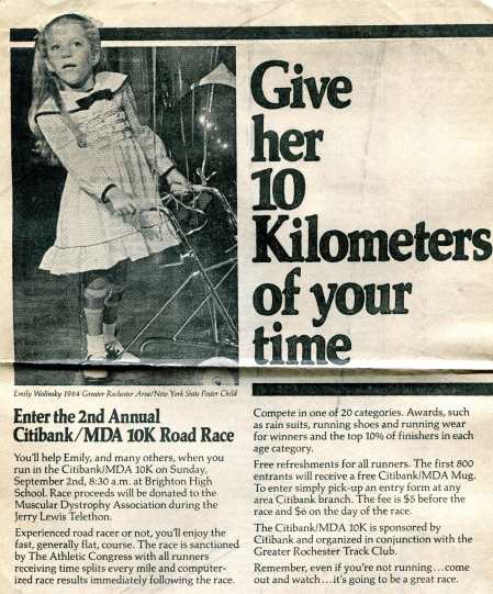 A black and white newspaper clipping that features an image of a little white girl in a frilly dress surrounded by balloons and looking off into the distance. She is holding onto a metal walker and wearing leg braces. The little girl, Emily Wolinsky, is described in the caption as the “1984 Greater Rochester Area/New York State Poster Child.” The headline of the clipping states, “Give her 10 Kilometers of your time,” and the article discusses a MDA road race for the Muscular Dystrophy Association.