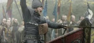  Image description: screenshot from an episode of Vikings, an original series on the History Channel. Ivar the Boneless is a young Viking warrior in full battle gear. He has a helmet over his head and nose. Sitting in a chariot, he is leading his army giving orders and one arm raised. 