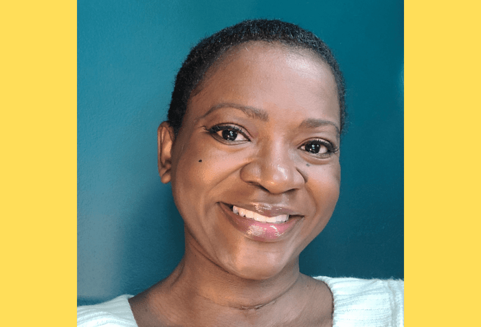Graphic with a yellow background showing a photo of a Black female with dark brown complexion, close cropped black hair, wearing a wide smile, and white sweater, in front of a teal colored wall.