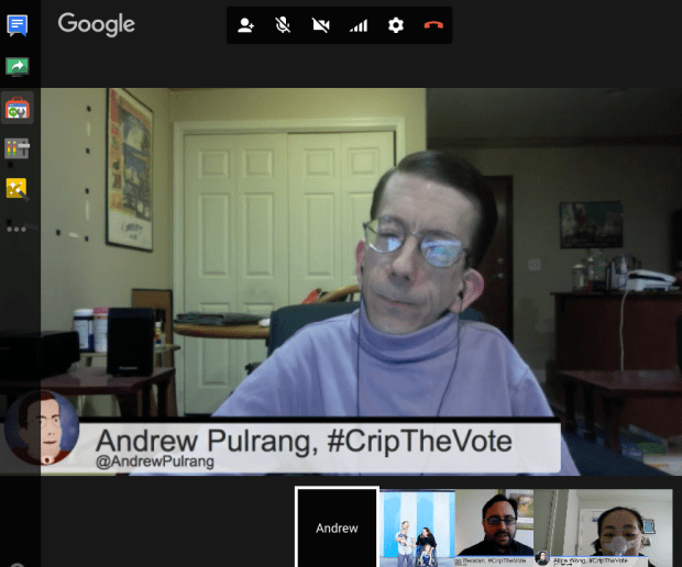 Screenshot of a Google hangout. A white middle-aged man with short brown hair with glasses. He is in a wheelchair and wearing a purple turtleneck. There is a horizontal panel below him that reads, Andrew Pulrang, #CripTheVote @AndrewPulrang